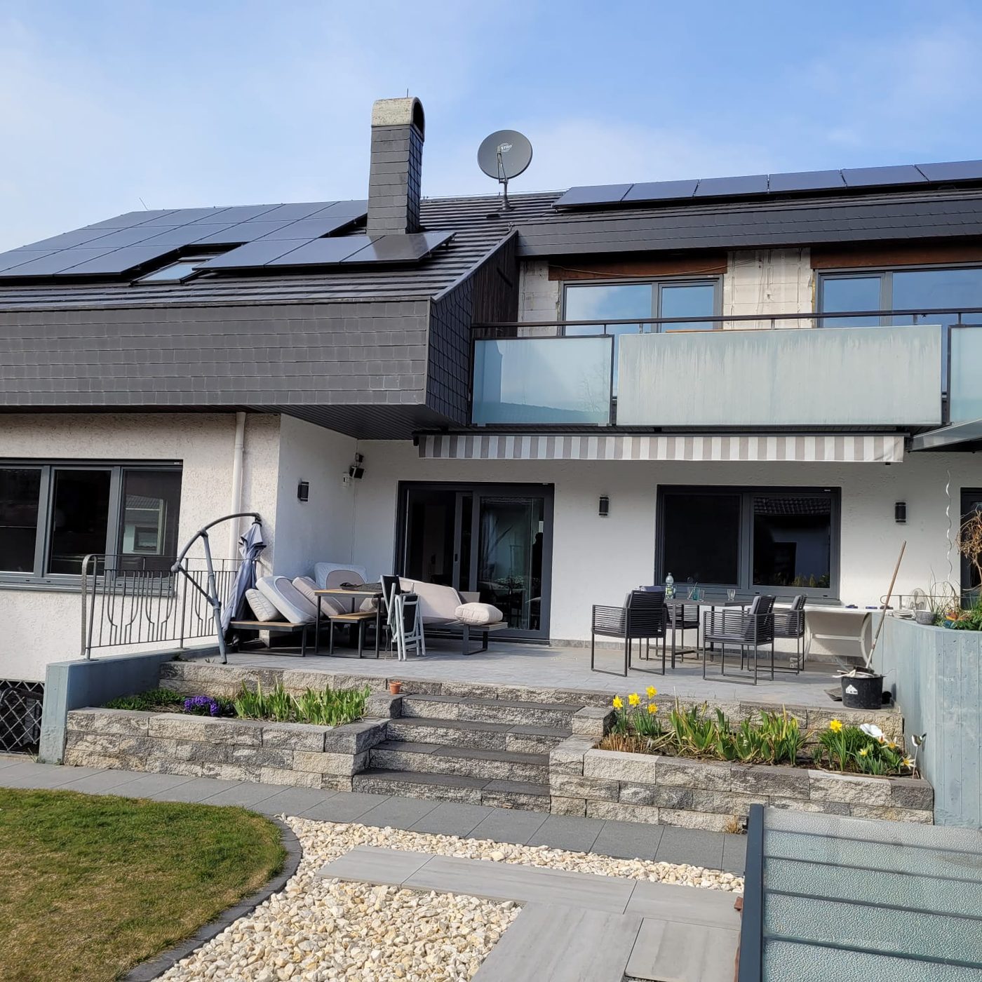 Terrasse mit großflächigen Panoramafenstern in Anthrazit